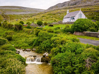 Scenic view of rural village church with stream landscape in Ireland