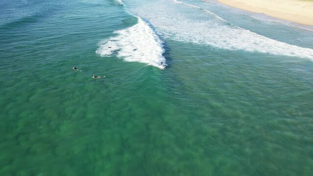 Surfers Surfing In The Blue Sea With Perfect Waves In Buddina Beach In Queensland, Australia. - aerial