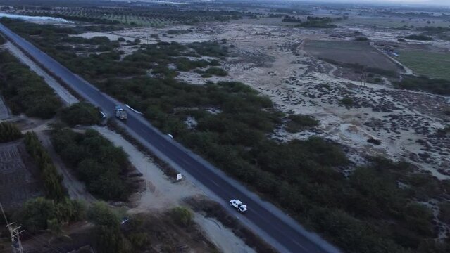 Aerial view of cars and trucks driving down a desert highway in beautiful landscape in Balochistan