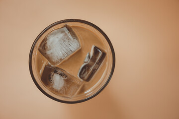 A cup of Mocha coffe filled with ice cubes. Refreshing summer drink.