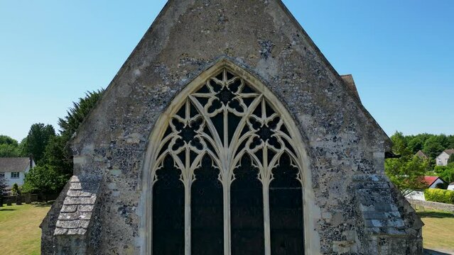 Rising boom-shot of St Mary's church in Chartham, rising in front of the main window, then to reveal a cross and the rear tower.