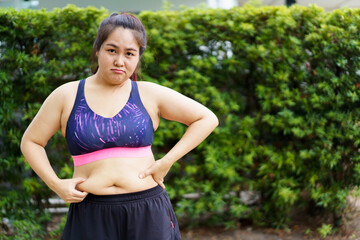 Unhealthy overweight Asian fat woman catching on her big belly and arm close up.