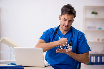 Young male student doctor holding molecular model