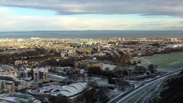 Aerial shot of Edinburgh in snow with Holyrood palace in the distance on a crips sunny winters day.