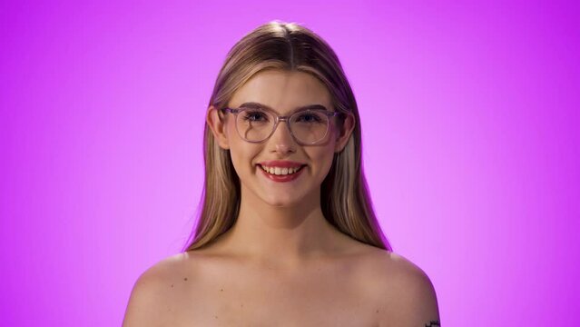 Happy young caucasian topless woman with red lipstick smiles to the camera