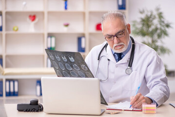 Old male doctor radiologist working in the clinic