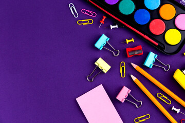 School office supplies stationery on a purple background desk with copy space. Back to school concept