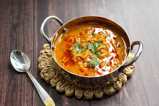 Traditional Sev bhaji or sev tamatar nu Shaak. its a sweet & spicy tomato curry topped with sev. Sev is a crisp fried gram flour vermicelli. Served with chopped onion and lemon. with Copy space.