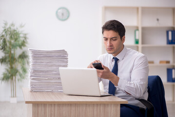 Young male employee and too much work in the office