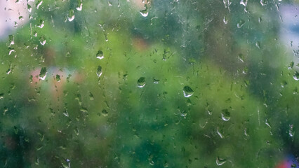 Water drops on glass after rain on a blurred background. Background with splashes of water. Misted...