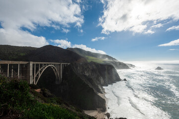 Exterior of Bixby bride, along US highway 1, while for is rolling in from the pacific ocean on a bright winter afternoon.