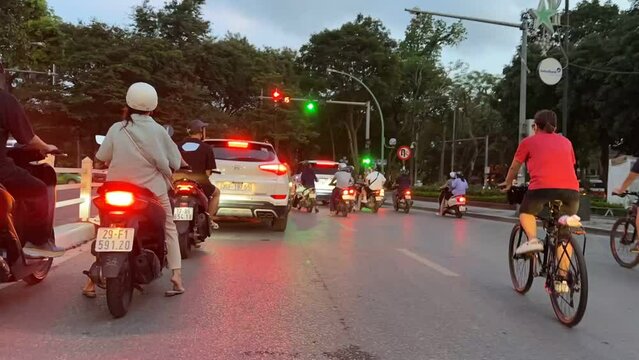 People riding mopeds in the city of Hai Noi in Vietnam