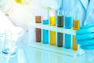 scientist with equipment and science experiments, laboratory glassware containing chemical liquid for research or analyzing a sample into test tube in laboratory