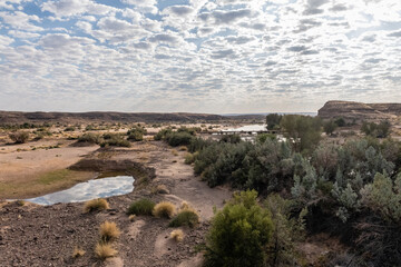 Low scattered clouds are reflected in the Fish River in Southern Namibia