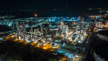 Fototapeta na wymiar Oil refinery plant industry factory zone, oil and gas petrochemical industrial, oil storage tank and pipeline steel at night scene shot, aerial view