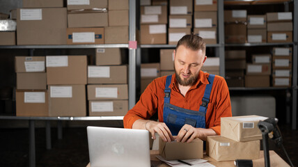 Warehouse worker sticking barcode label on a package box, order for shipping in a warehouse.