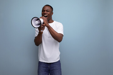 positive handsome dark-skinned young american guy in white t-shirt with megaphone