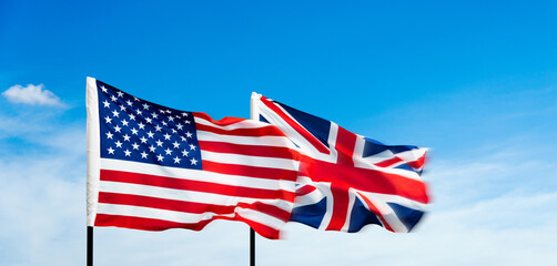 USA and Britain flags against blue sky background © xy