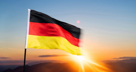 German flag waving against sunrise sky background