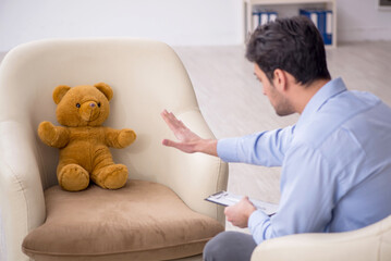 Young male psychologist meeting with toy bear