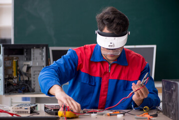 Young male repairman repairing computers in the classroom