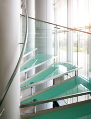 Modern glass spiral staircase with metallic handrails