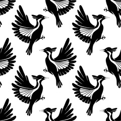 Seamless vector pattern of flying woodpeckers silhouettes. Surface design. Texture with black stylized bird on white background.