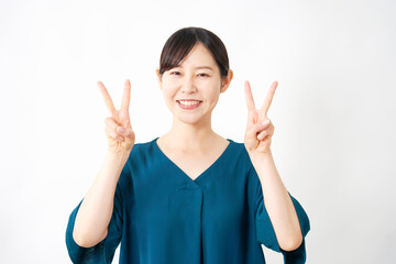 両手でピースサインするミドルエイジの女性　白背景