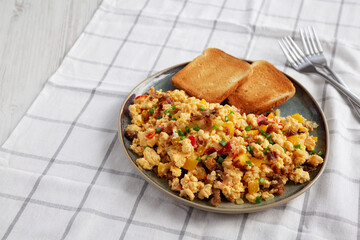 Homemade Fiesta Scrambled Eggs with Peppers and Toast on a Plate, side view. Copy space.