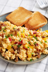 Homemade Fiesta Scrambled Eggs with Peppers and Toast on a Plate, side view.