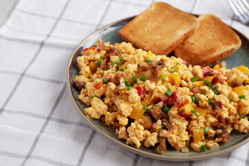 Homemade Fiesta Scrambled Eggs with Peppers and Toast on a Plate, side view. Copy space.