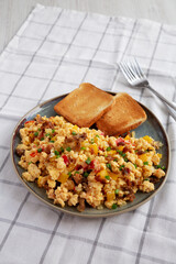 Homemade Fiesta Scrambled Eggs with Peppers and Toast on a Plate, side view.