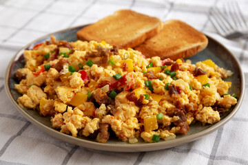 Homemade Fiesta Scrambled Eggs with Peppers and Toast on a Plate, side view. Close-up.