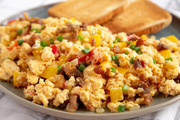 Homemade Fiesta Scrambled Eggs with Peppers and Toast on a Plate, side view. Close-up.