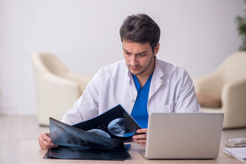 Young doctor radiologist sitting at the hospital