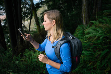 Young Woman Hiking with Phone in Alaska