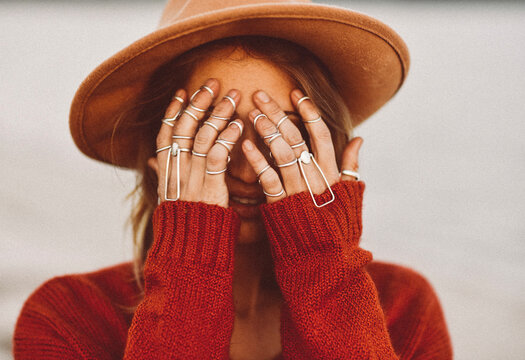 Young Woman Covering Face with Hands in Silver Ring Splints
