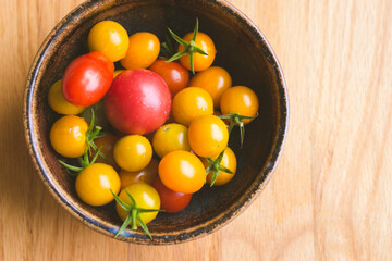 Fototapeta na wymiar Bowl of yellow and red cherry tomatoes.