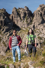 Naklejka premium Beautiful view to couple of friends hiking on altitude fields