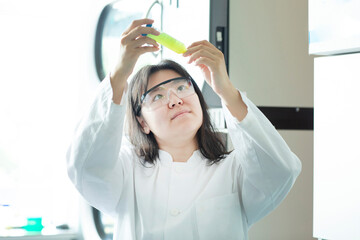 young chinese scientist female controlling a sample in a tube
