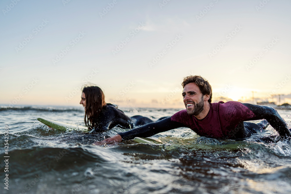 Wall mural surfers with boards swimming in ocean.