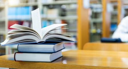 Stack of books opened on library desk