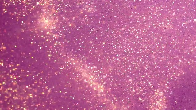 Golden Dust Particles Motion In Violet Fluid. Gold particles moving background. Abstract backdrop of natural glitter sparkling sequins floating in liquid.