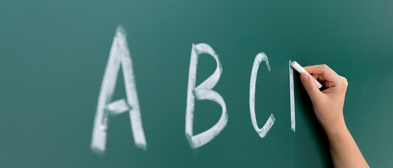 Hand writing alphabet abcd on chalkboard