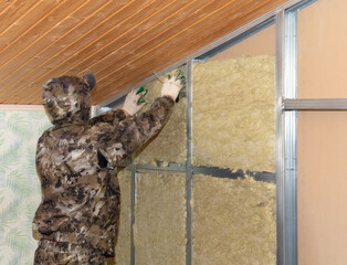 Workers insulate the wall in the room