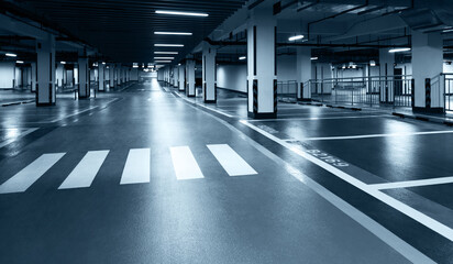 Empty underground parking lot in modern building. - obrazy, fototapety, plakaty