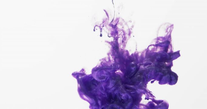 Slow motion video of purple watercolor ink mixing in water against grey background