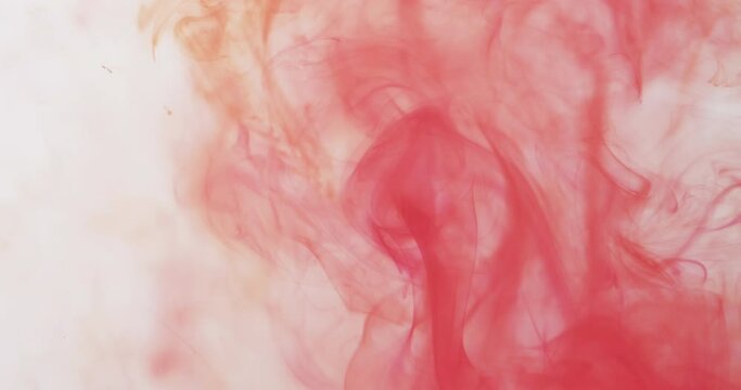 Slow motion video of pink watercolor ink mixing in water against grey background