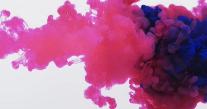 Slow motion video of pink and blue watercolor ink mixed in water against grey background