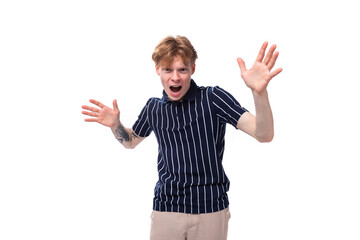 emotional positive 25 year old blond man with tattoos in a striped polo posing on a white background